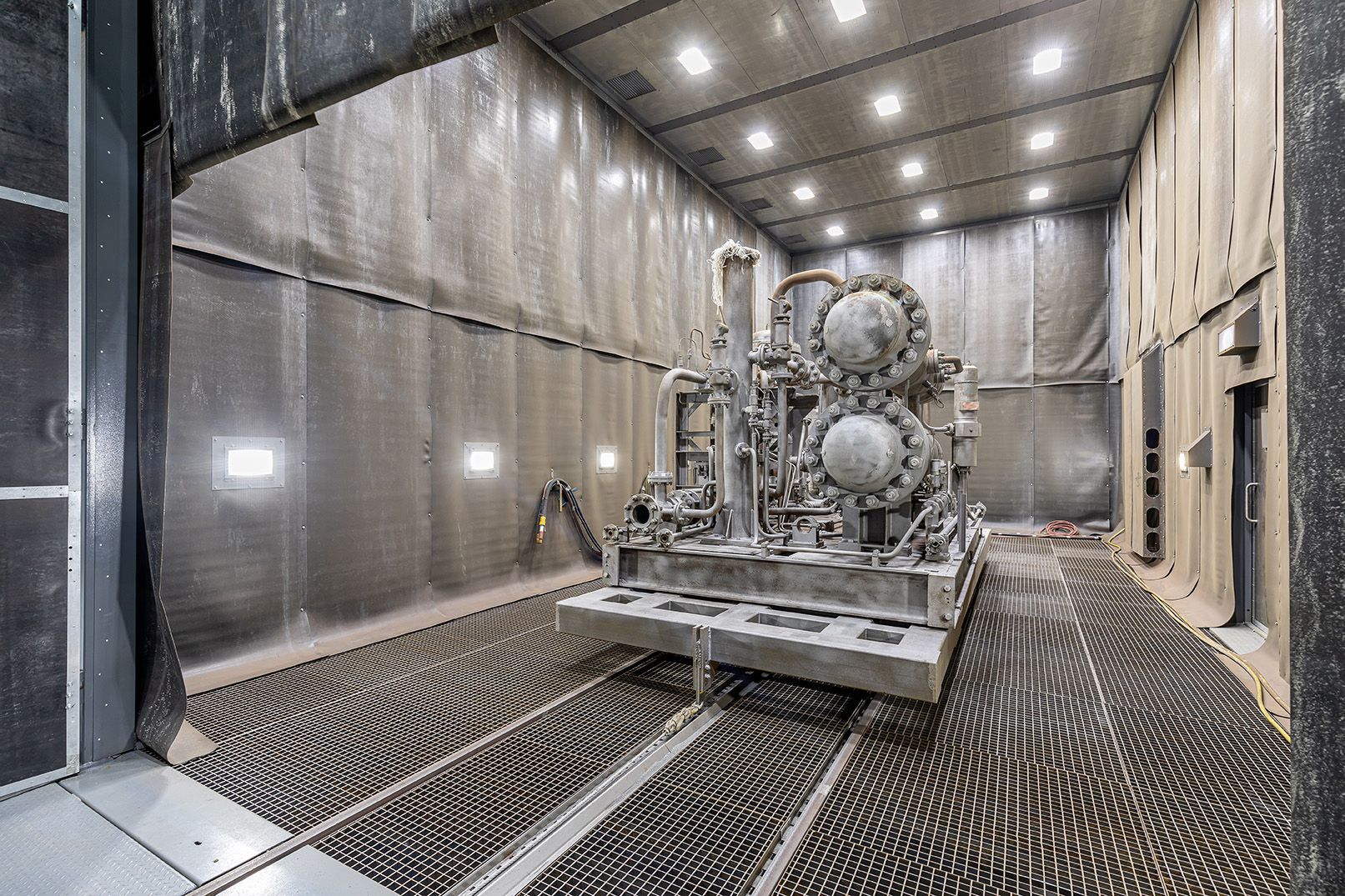 A large machine is sitting in a room with a lot of dust on the floor.