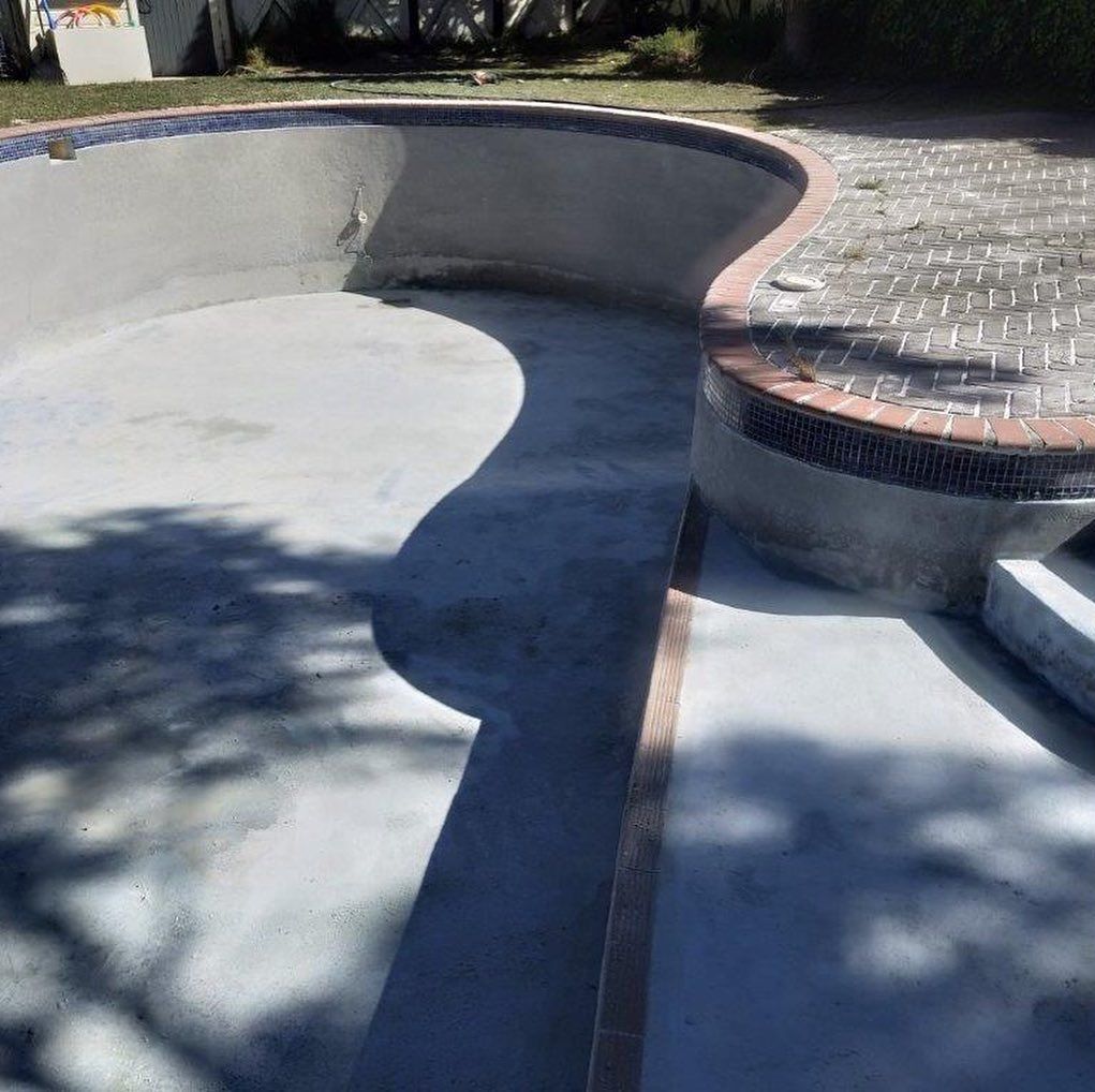 A swimming pool with a brick walkway leading to it