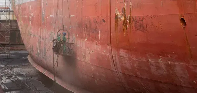 A large red ship is sitting in a dock.