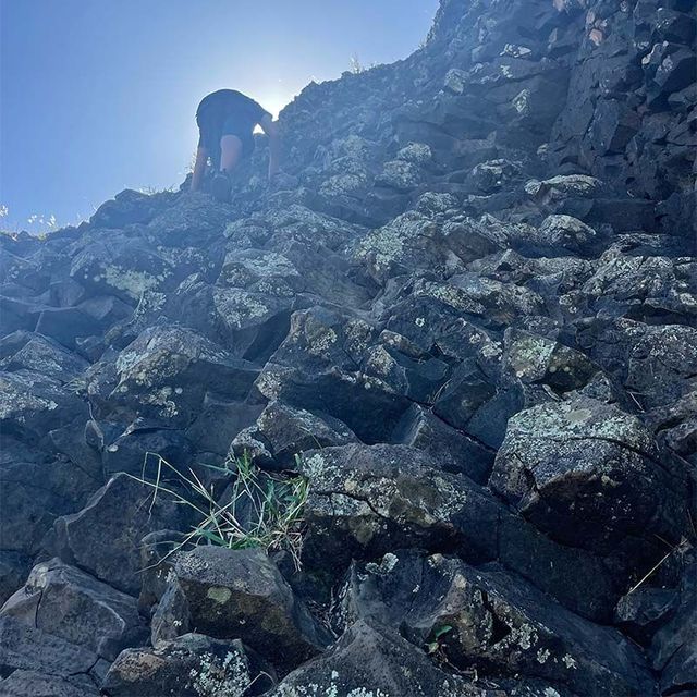 a person is climbing up a rocky hill