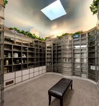 Curved wall of memorial columbarium niches with a bench and skylight in a quiet mausoleum room