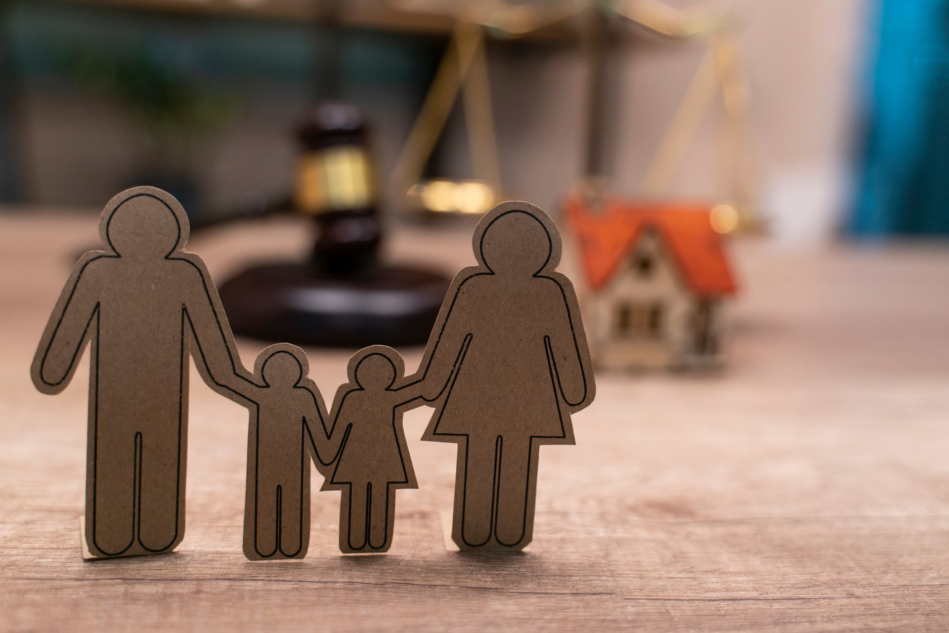 Family Law—Wooden cutouts of family with gavel and house model symbolizing legal matters.