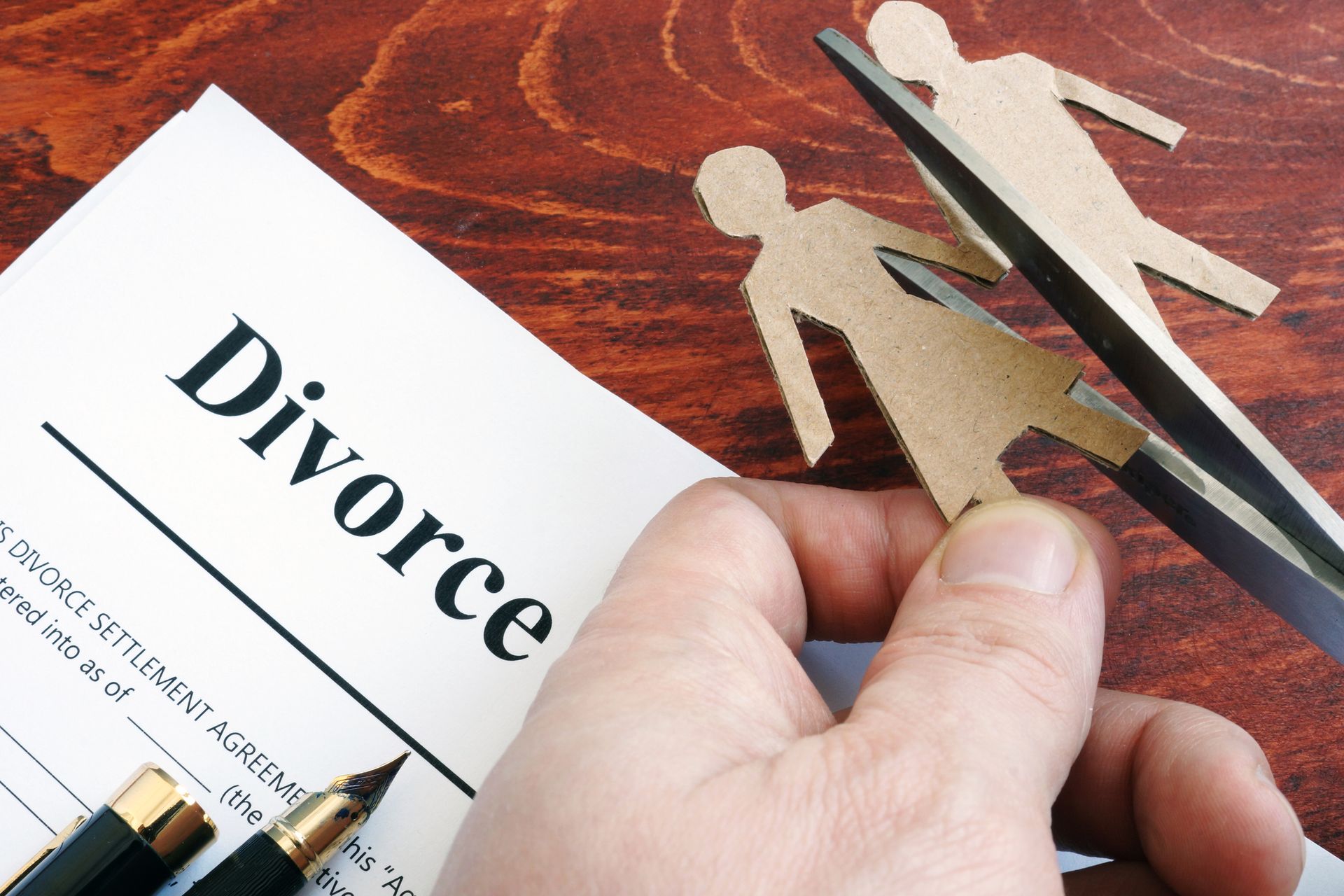 Couple figures beside divorce form on desk, featuring professional divorce lawyer legal service.
