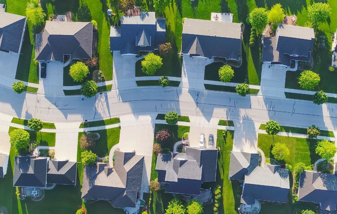 An aerial view of a residential neighborhood with lots of houses and trees.
