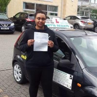 Learner driver student driving car with instructor. happy and confident smiling girl