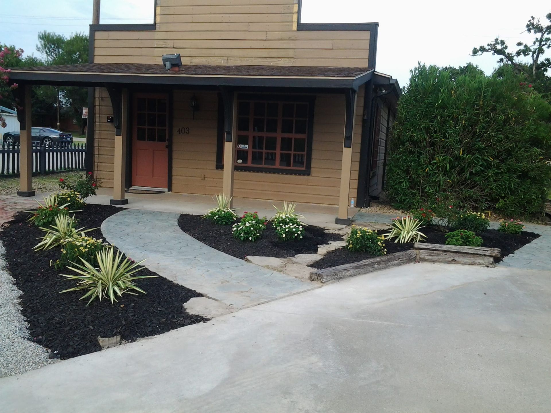 A brick building with a porch and a walkway in front of it