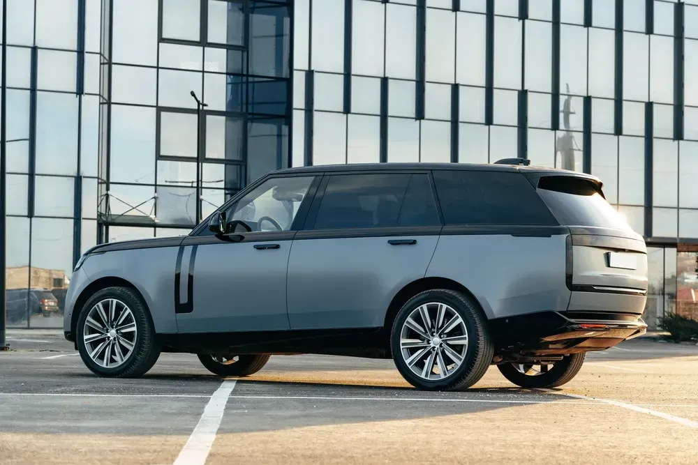 Luxury SUV car parked against a background of glass building