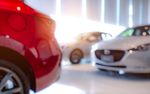 A blurry picture of cars in a showroom.