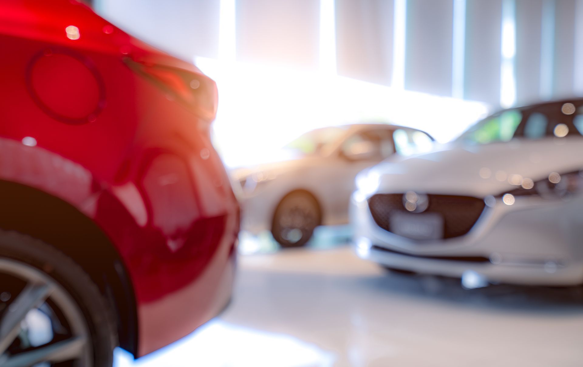 A blurry picture of cars in a showroom.
