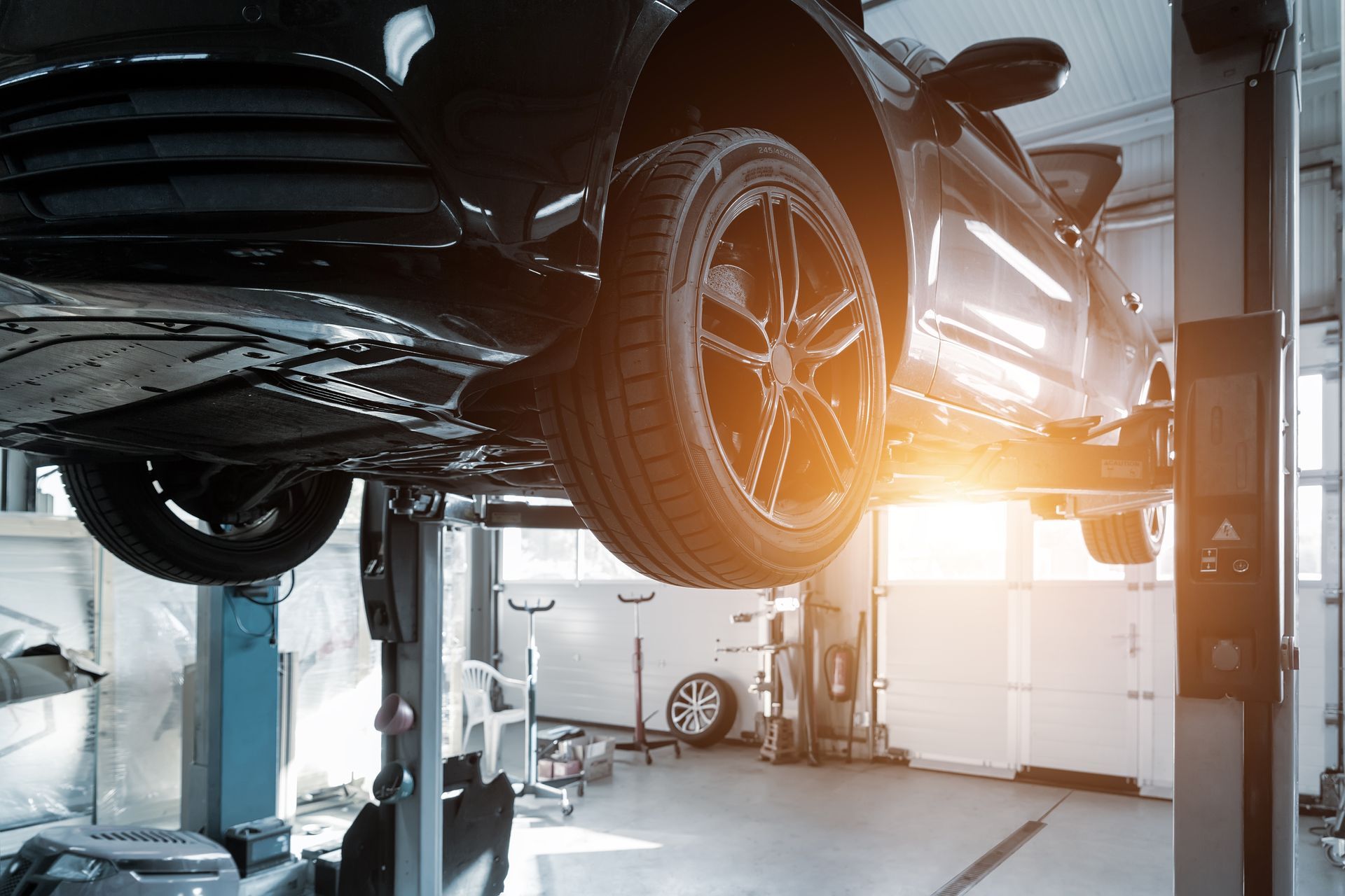 A car is sitting on a lift in a garage.