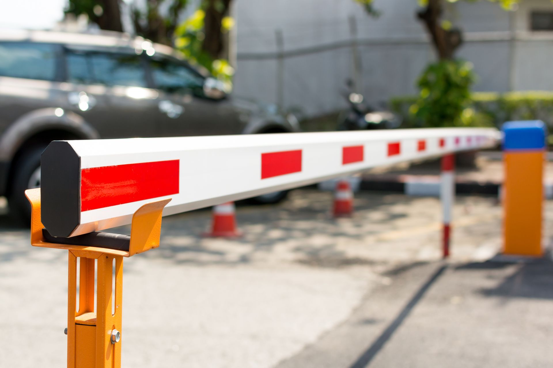 A car is parked behind a barrier in a parking lot.