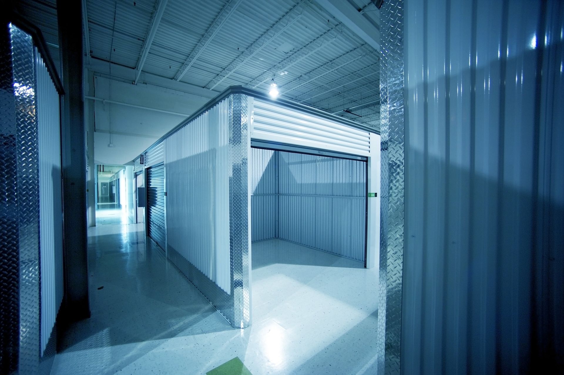 A hallway in a building with a garage door open.