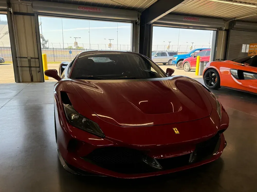 Person applying window tint to a car window, inside a car, with hands smoothing the film.