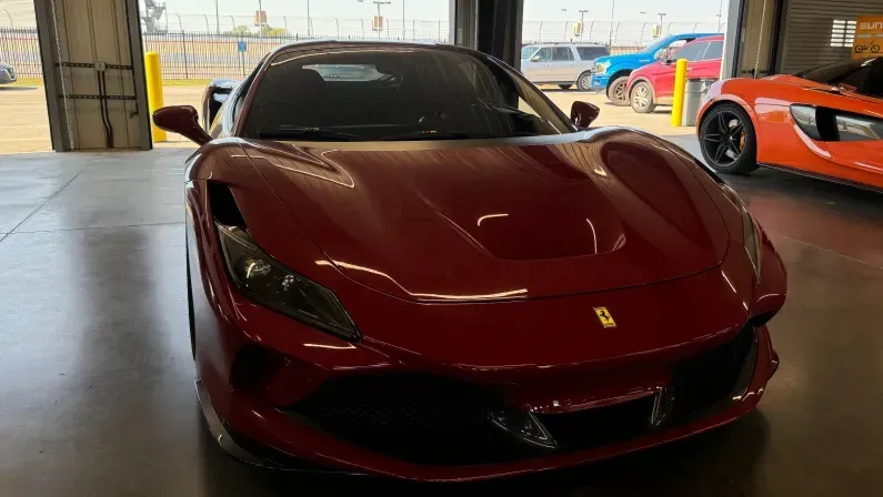 Nashville, TN, USA - October 12, 2024: A red sports car displayed inside a luxury garage during a motorsport event