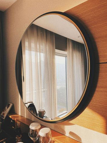 Una vasca da bagno rettangolare bianca con rubinetto moderno, incastonata in una terrazza di legno con vista sul tramonto sull'oceano.