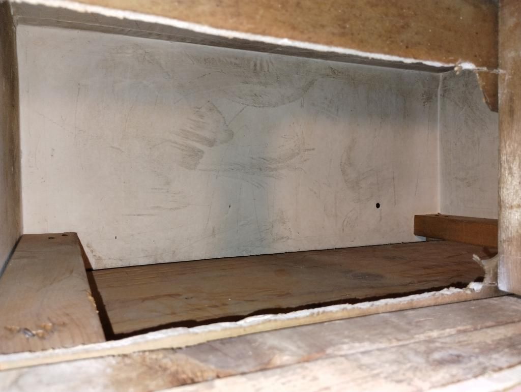 An empty room with a wooden floor and a white wall