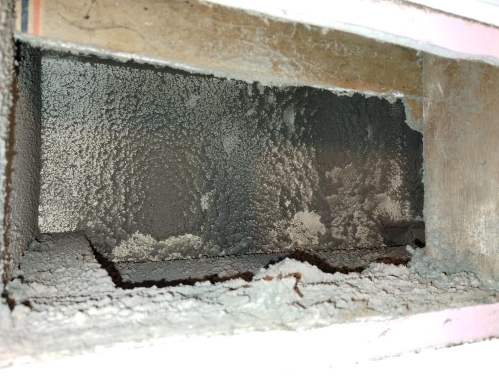 A hole in a wall with a piece of concrete in it