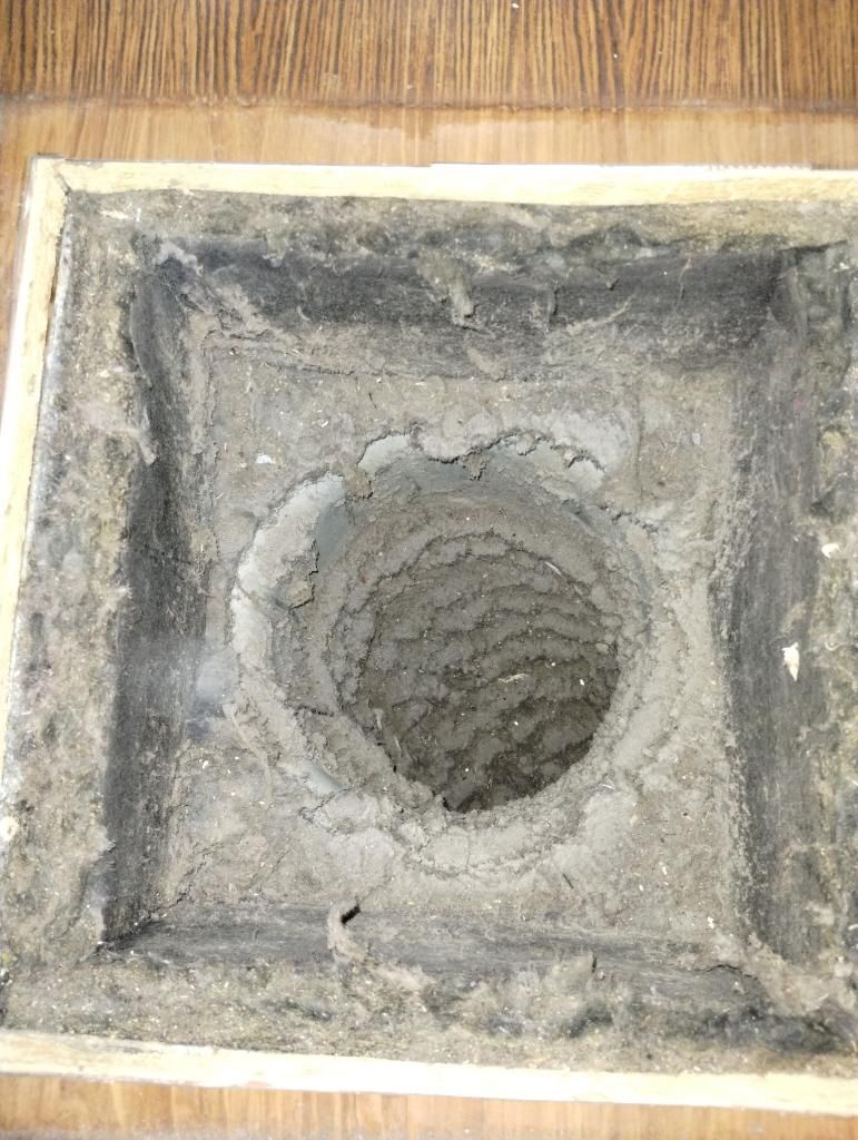 A dirty air vent with a hole in the middle of it