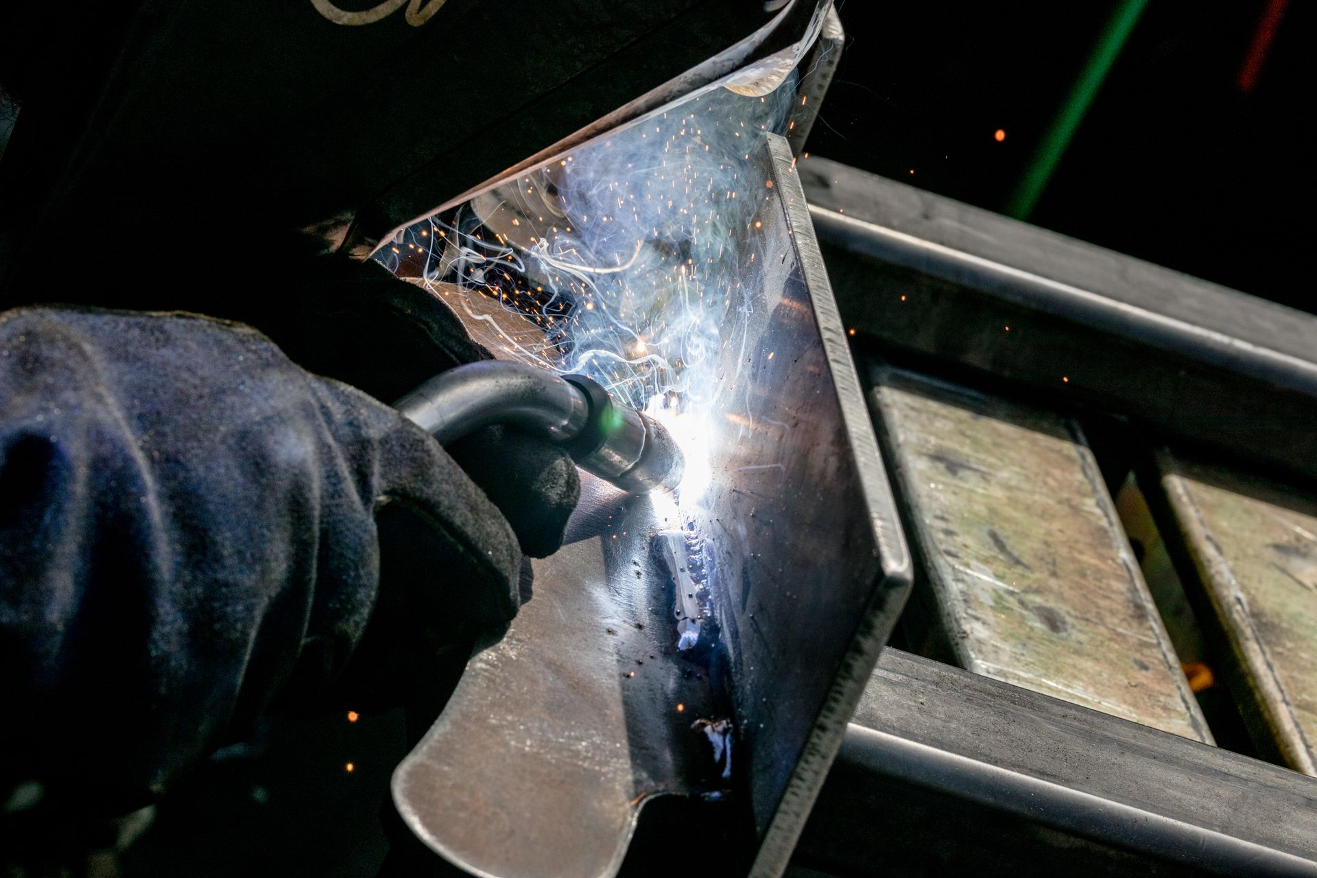 A welding team member performing TIG welding on steel plates