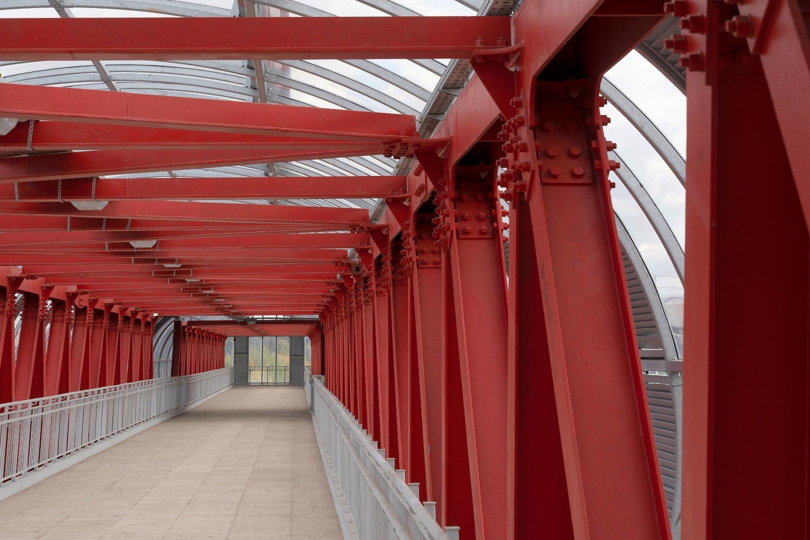 Steel-roofed pedestrian crossing with red beams