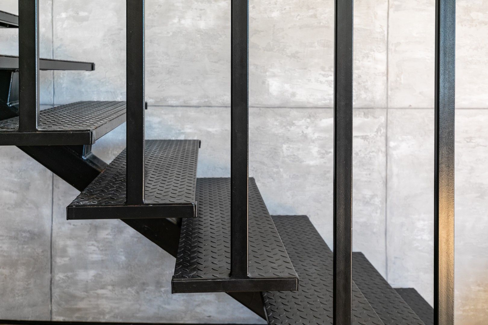 Modern black staircase on concrete wall in loft