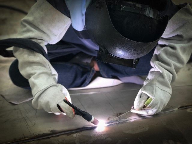 Craftsman using TIG welder to weld stainless plate