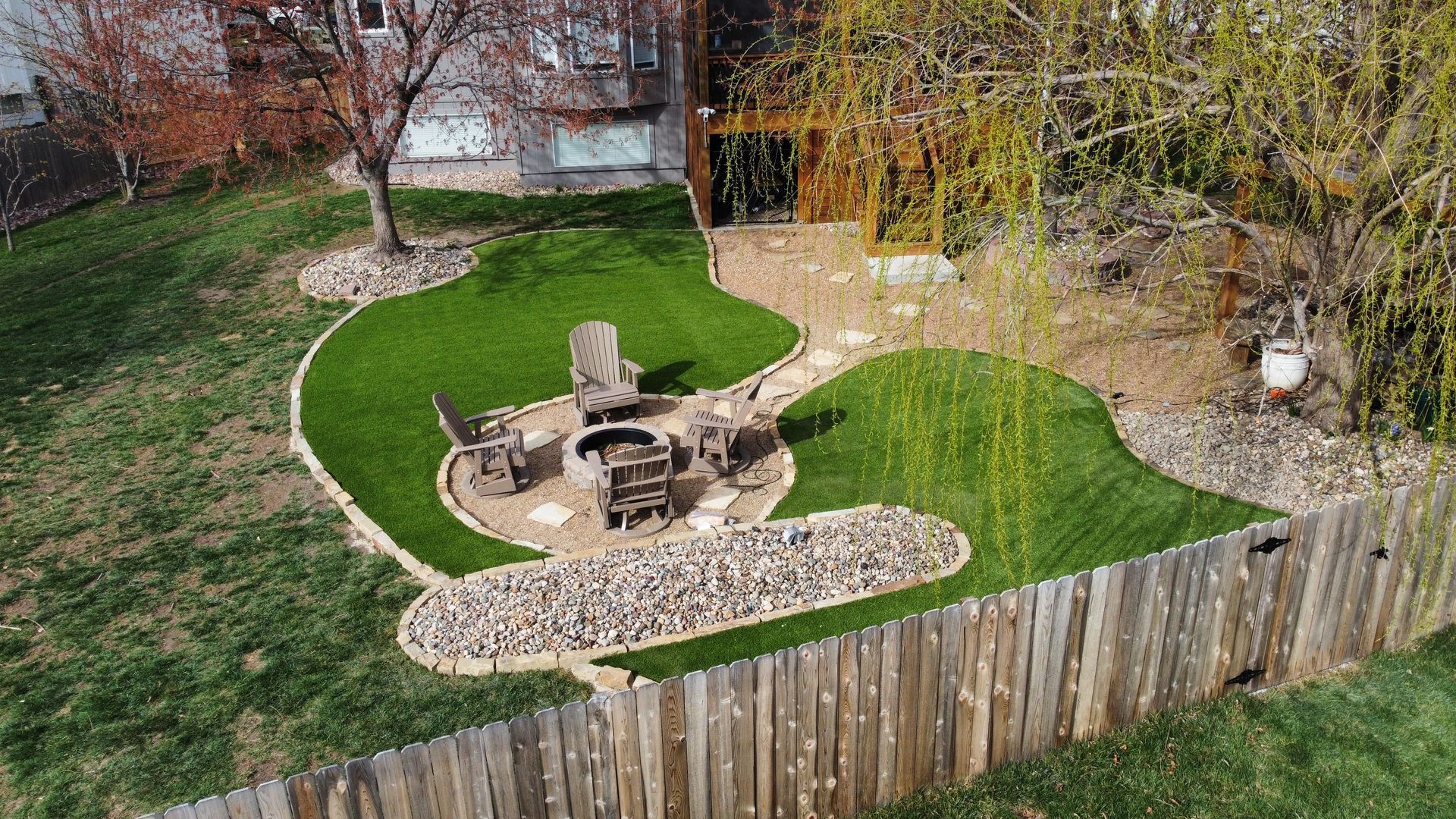 A large house with a pool and am artificial lawn in front of it.