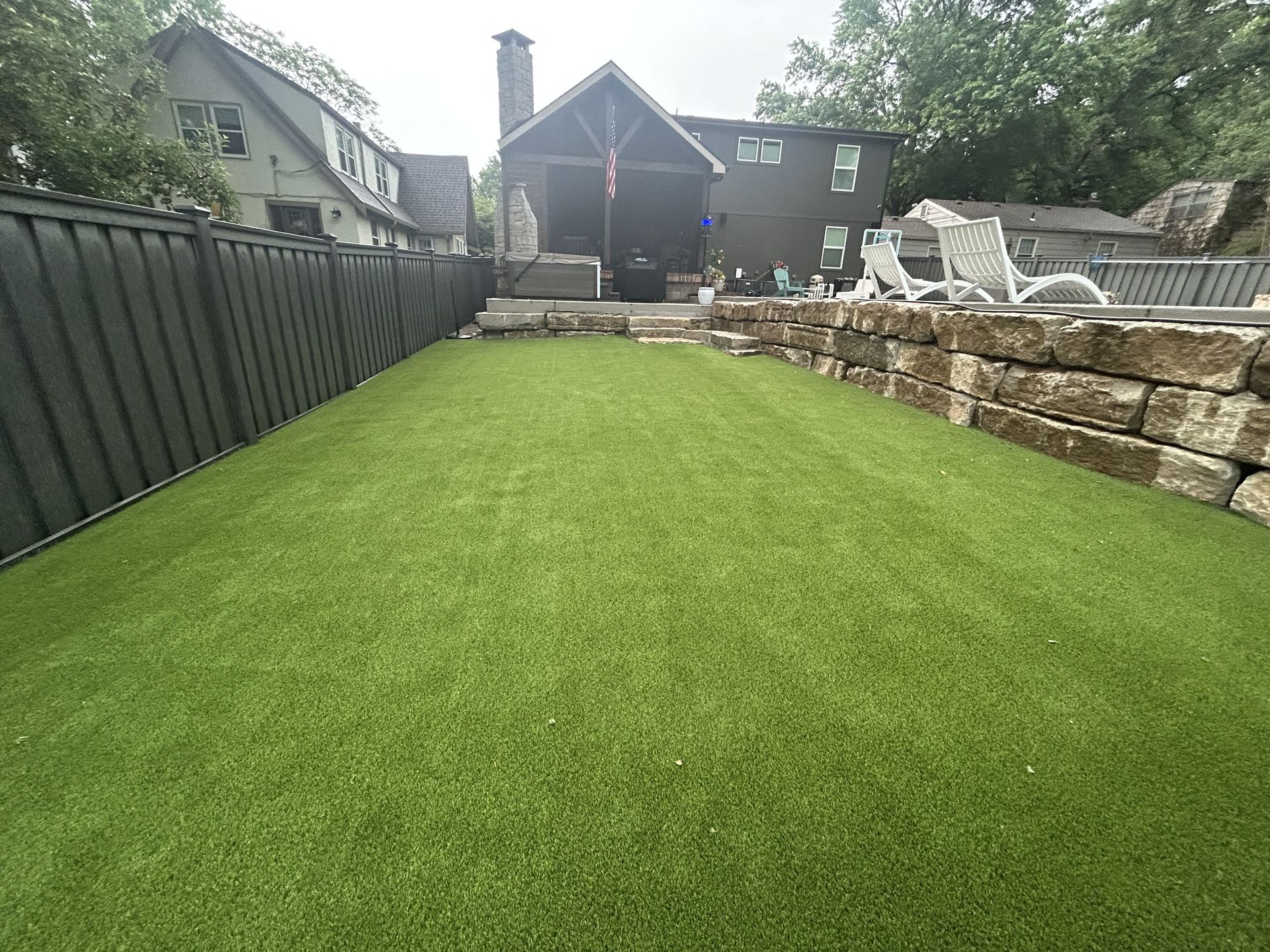 A brick house with a green artificial turf lawn in front of it.