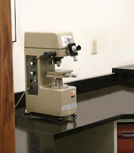 A microscope is sitting on a counter in a lab.