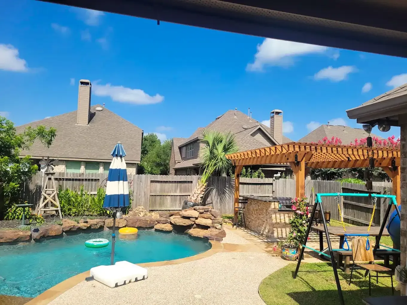 There is a swimming pool in the backyard of a house.