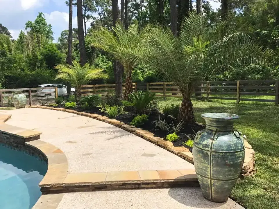 A large vase is sitting next to a swimming pool.