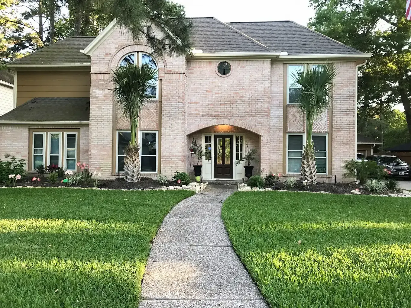 A large brick house with a walkway leading to the front door.