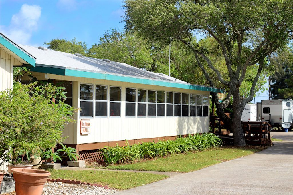 A white house with a green roof and a lot of windows
