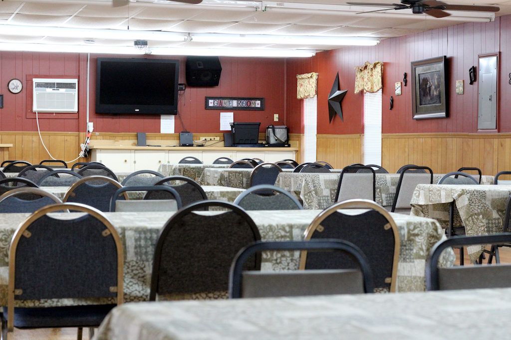 A dining room with tables and chairs and a flat screen tv
