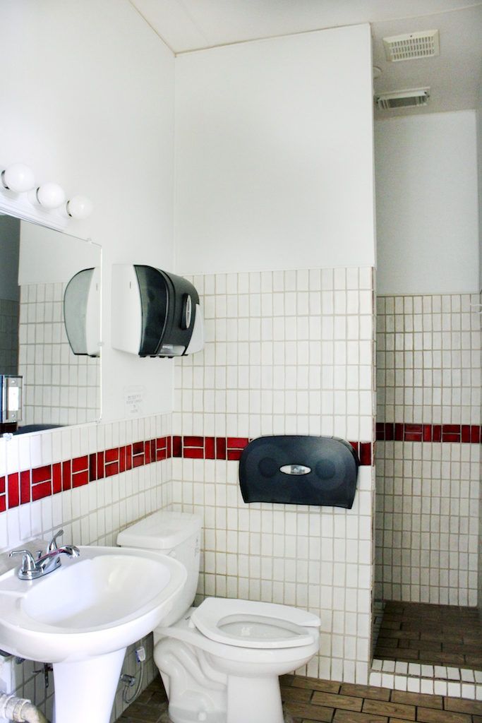 A bathroom with a toilet a sink and a mirror