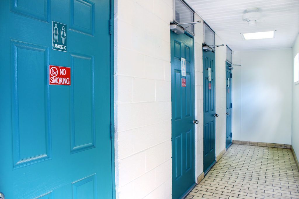 A hallway with blue doors and a red sign that says no parking.
