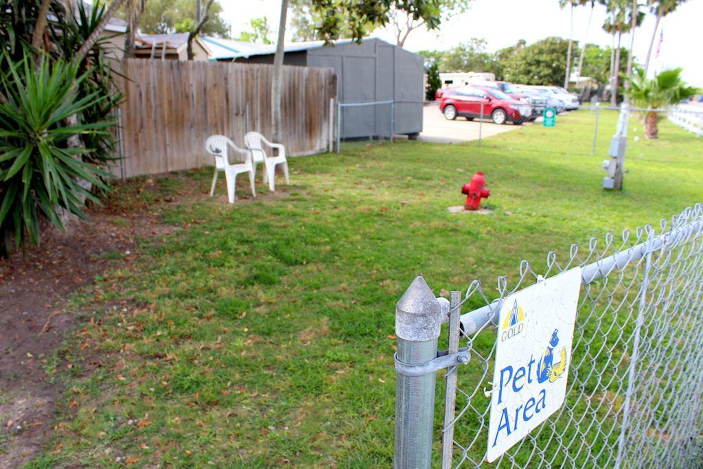 A sign on a chain link fence says pet area