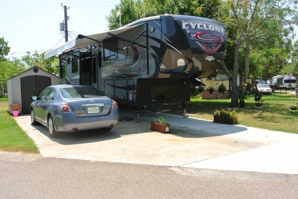 A car is parked in front of a rv that says cyclone
