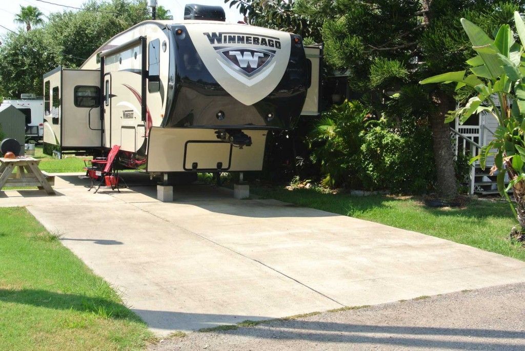 A rv parked in a grassy area with a picnic table