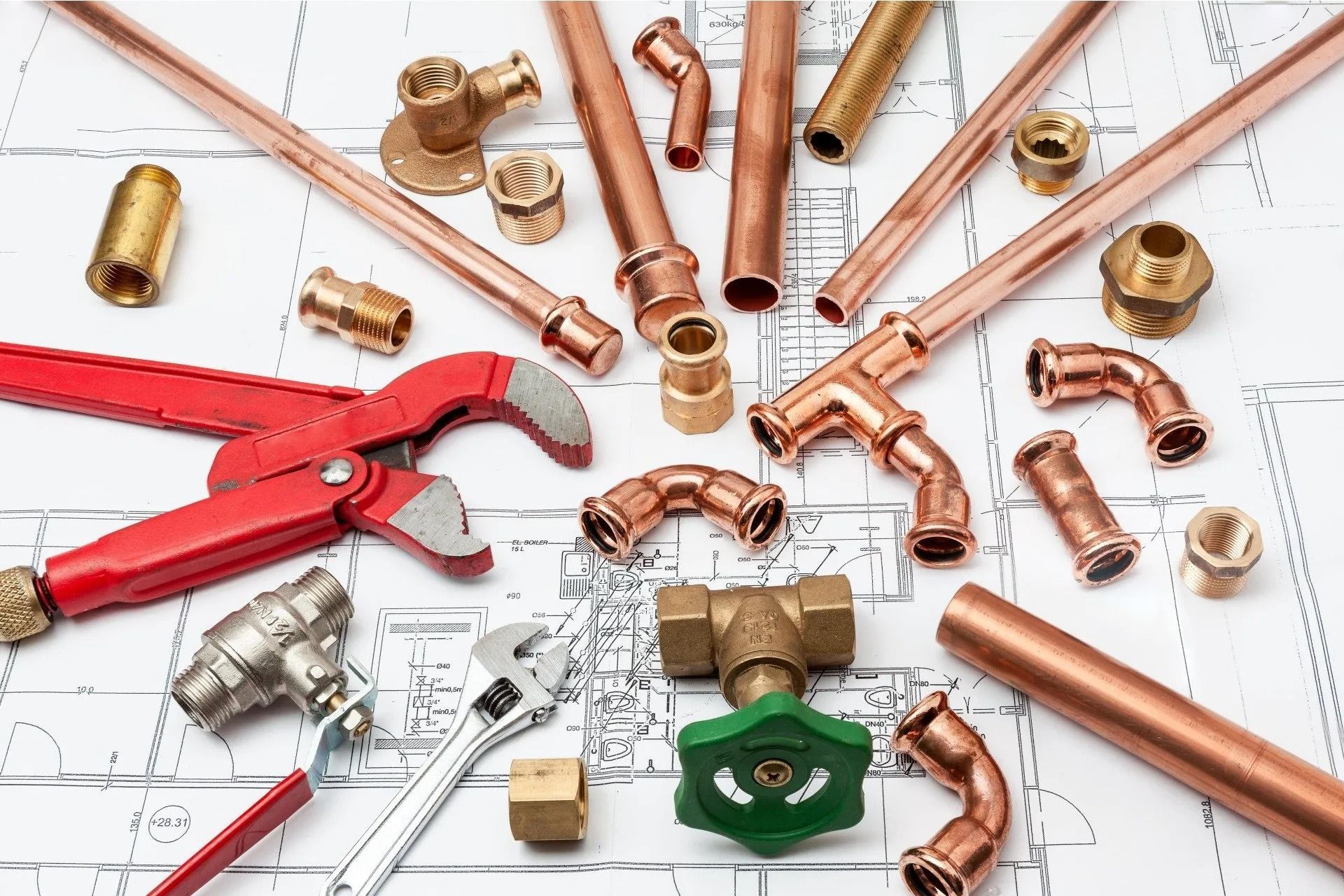 Plumbing Tools and Copper Pipes Arranged on A Blueprint — Weav Plumbed in Emerald, QLD