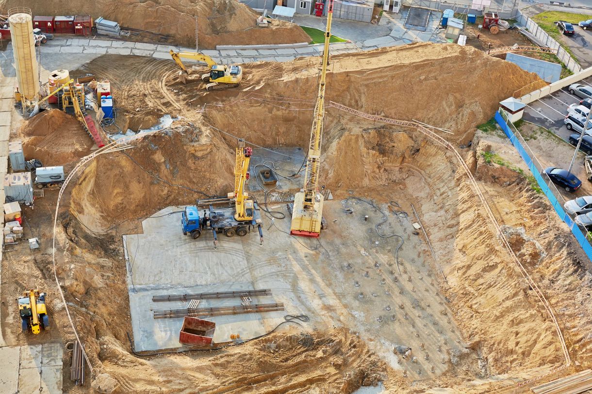 Foundation ditch with construction machinery at construction site