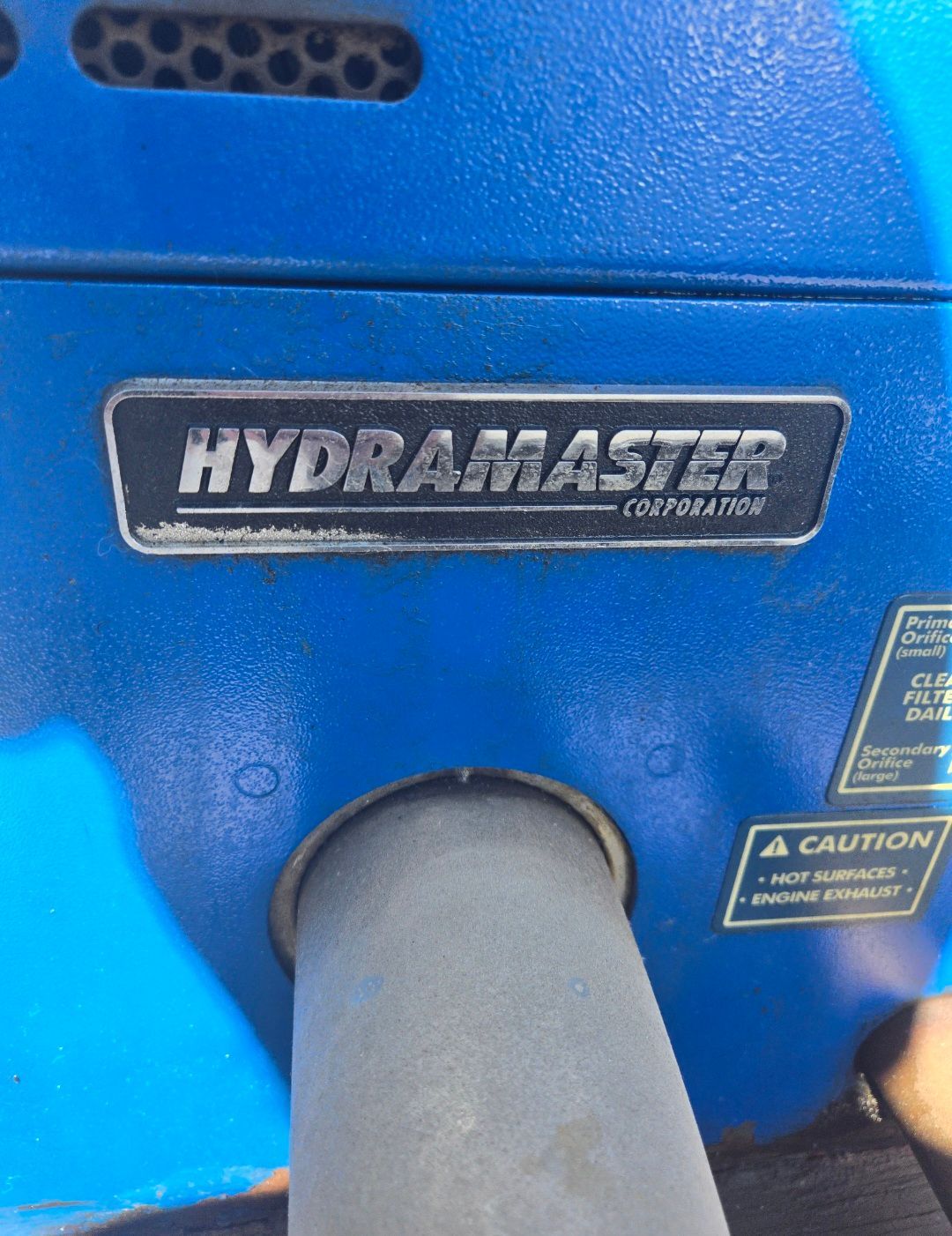 Blue HydraMaster machine with silver logo and exhaust pipe.
