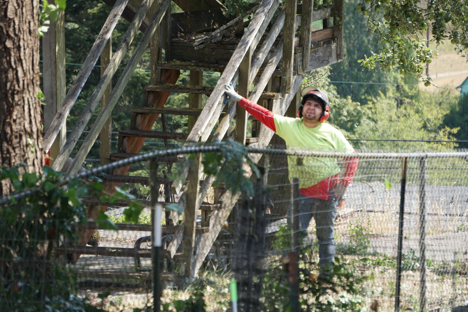 Man in safety gear standing after job completed. Sunny outdoors.