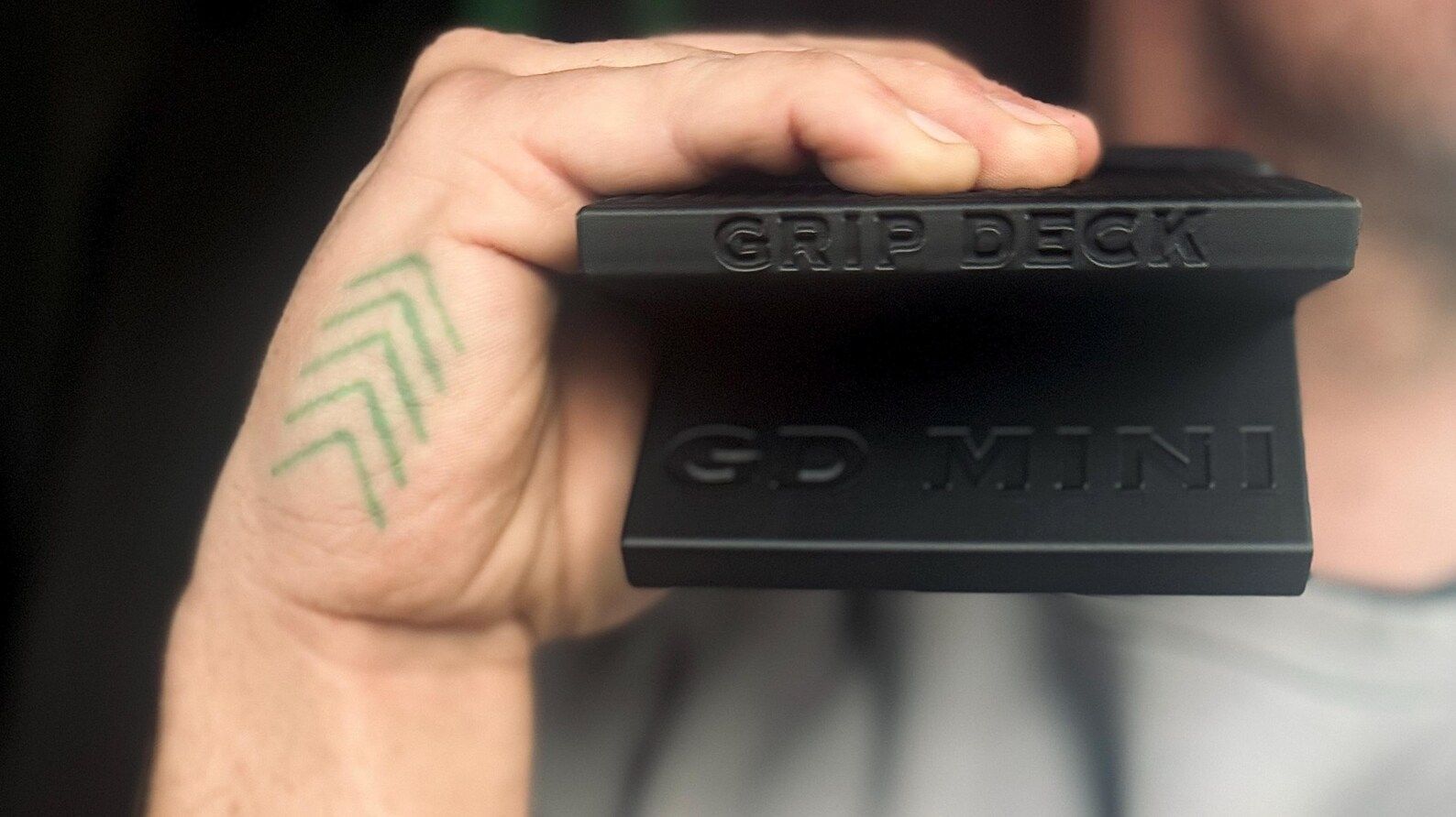 Hand holding a black grip tool with words GripDeck GD MINI