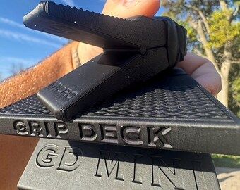 Man holding black plastic grip tool with words GripDeck GD MINI