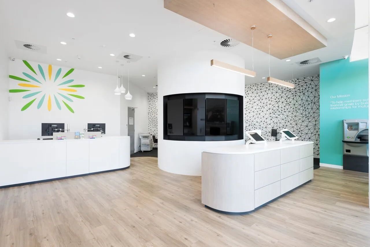 Modern Office Reception Area With White Desks, Teal Accent Wall, and Wood Flooring — ATH Projects in Kirrawee, NSW