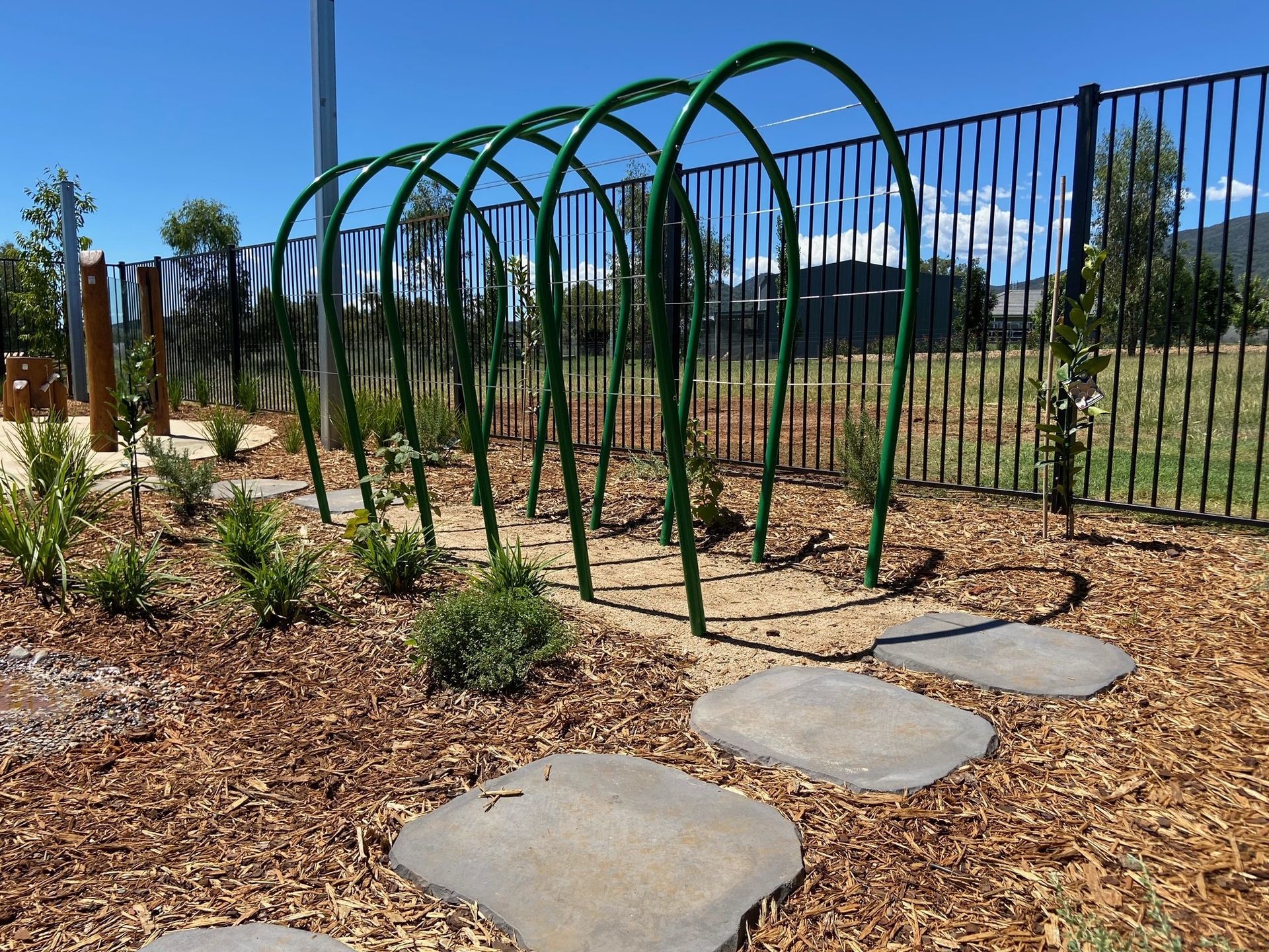 Green Arched Structures Over Stone Path in Garden — ATH Projects in Moore Creek, NSW