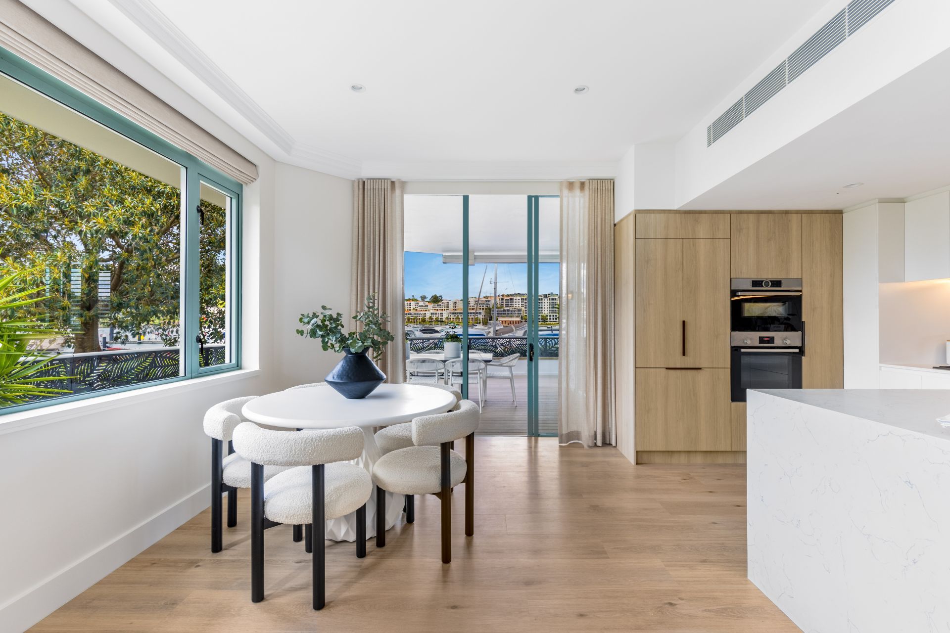 Dining Room With Table, Chairs, and View to a Waterfront Balcony — ATH Projects in Drummoyne, NSW