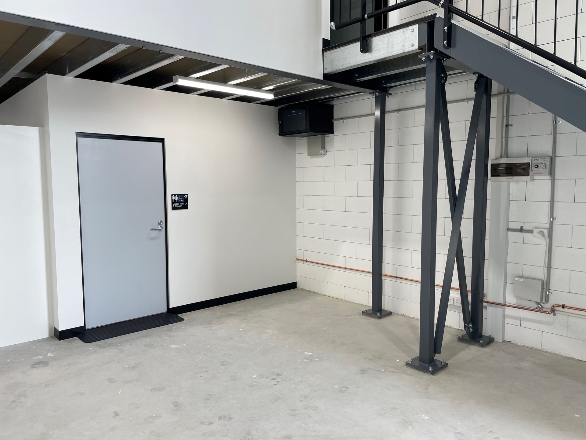 Gray Door, Beneath a Metal Mezzanine — ATH Projects in Kirrawee, NSW