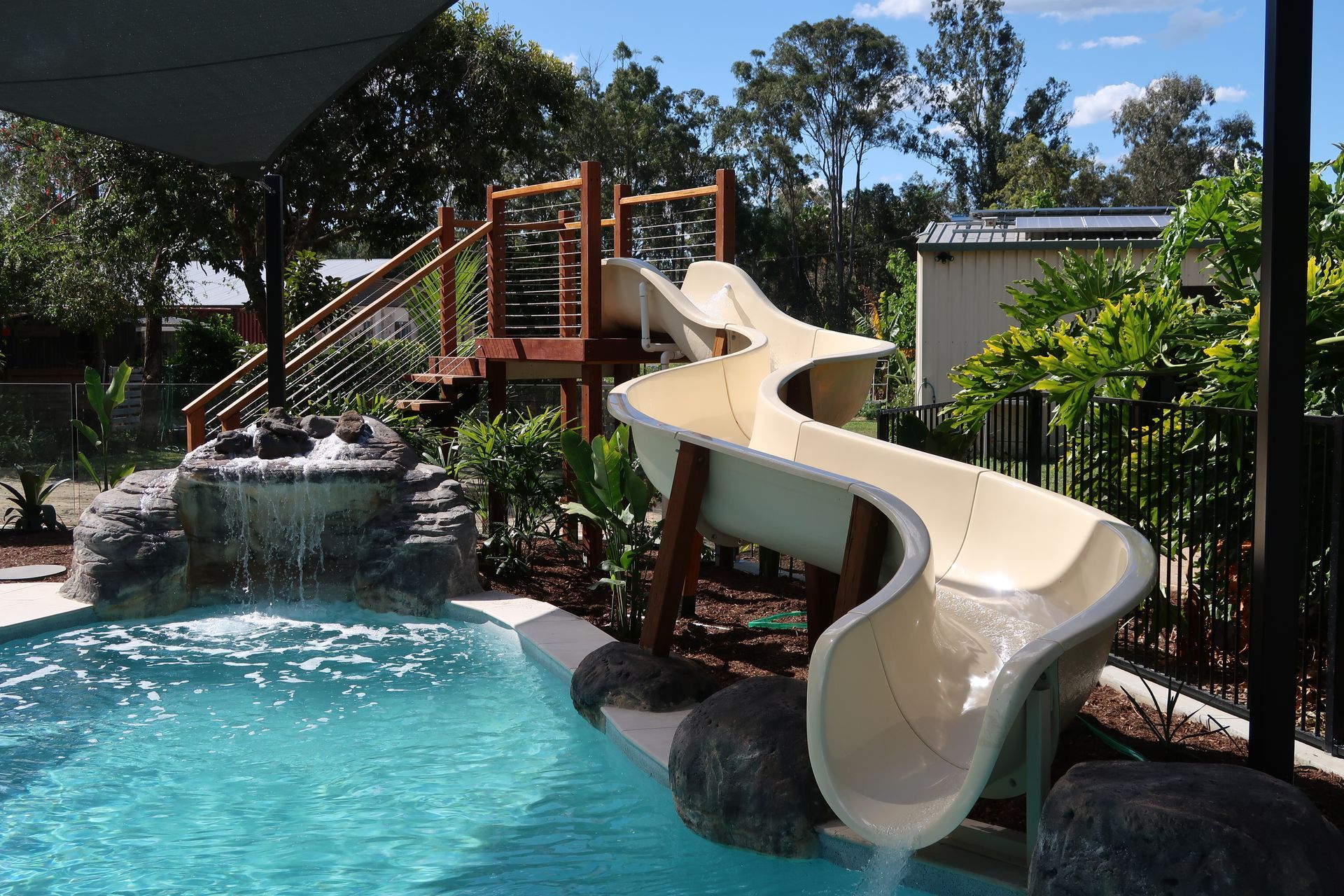 Swimming Pool With Water Slide, Waterfall, and Wooden Structure — ATH Projects in Bellmere, QLD